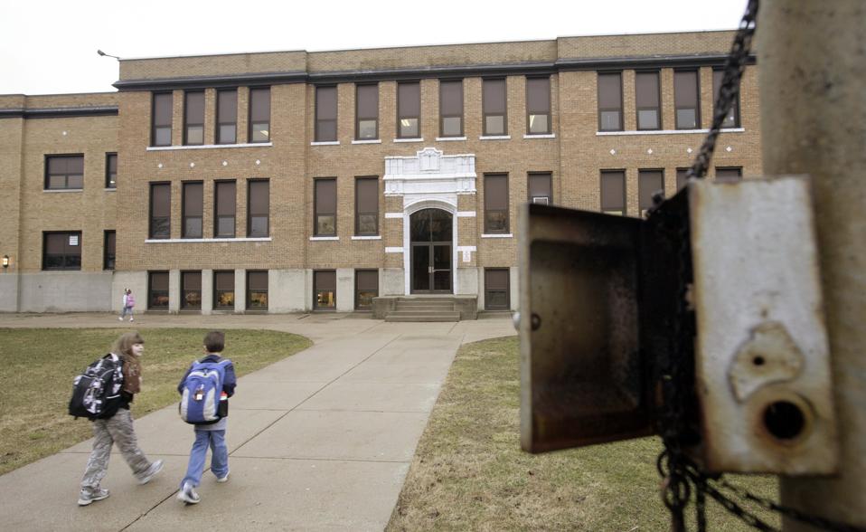 school kids with backpacks heading into school